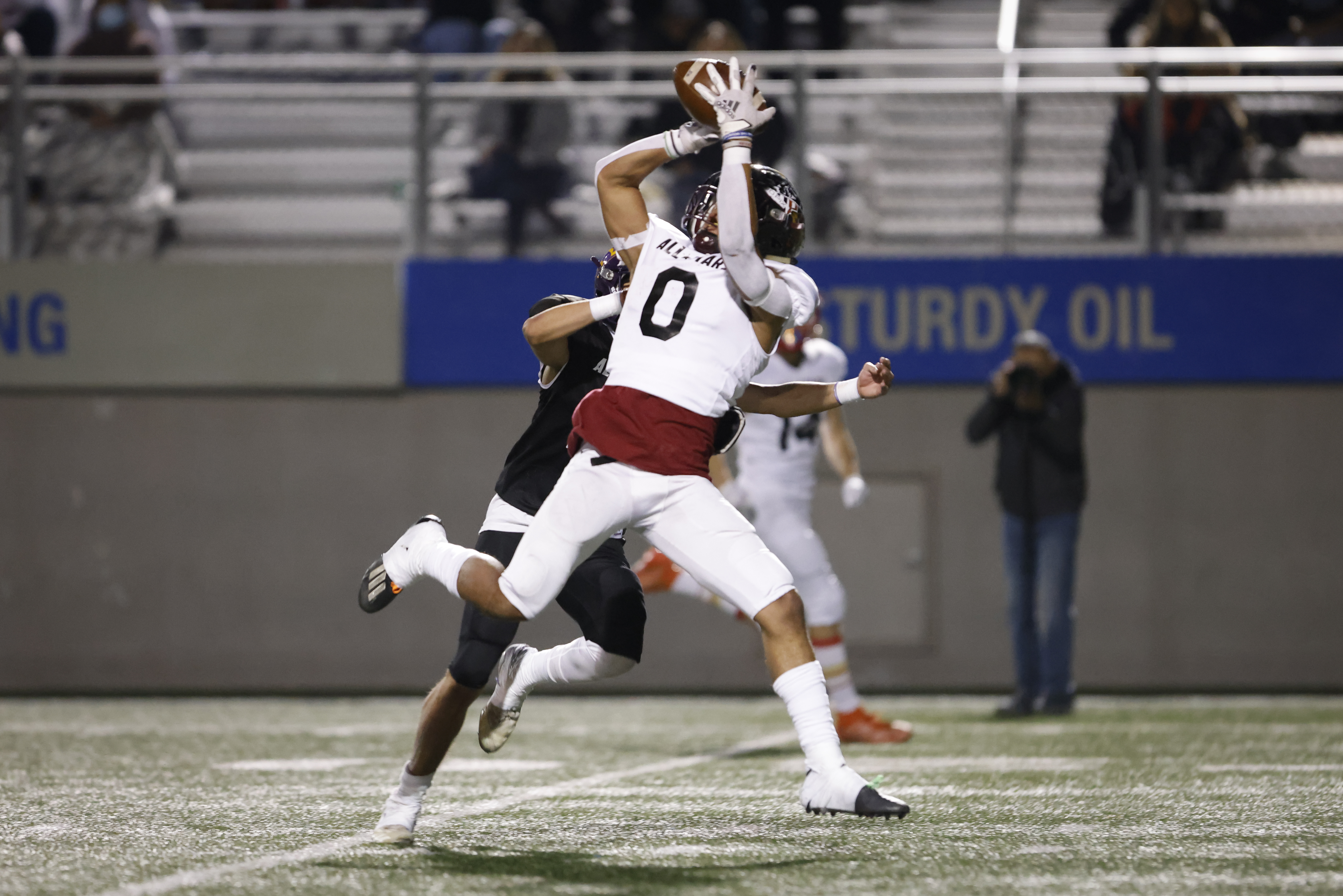 completed-catch-by-football-player-in-white-uniform-and-number-0.jpg